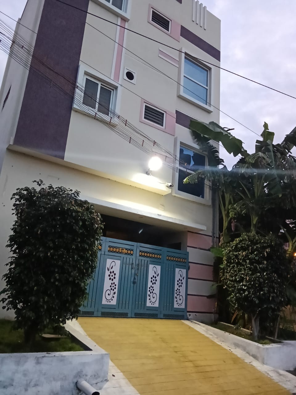 Evening exterior view showing compound gate and garden